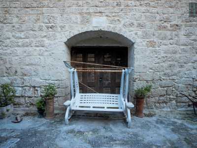 Tra tavoli e oggetti lasciati un po� alla rinfusa, notiamo l�ingresso in legno della masseria...